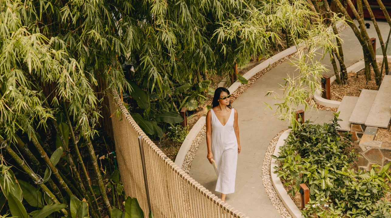 A guest walking the bamboo-lined paths between villas